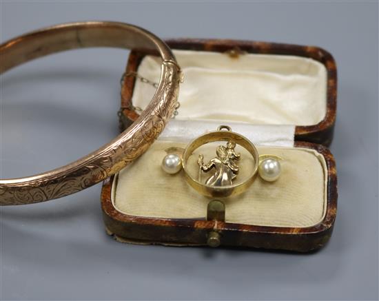 An engraved 9ct gold hinged bangle, a pair of dress studs and a St. Christopher pendant.